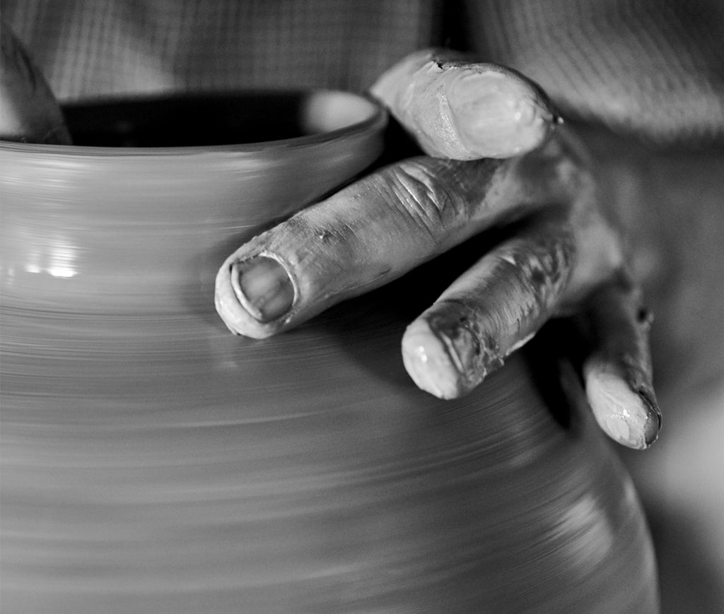 Hand shaping pottery
            